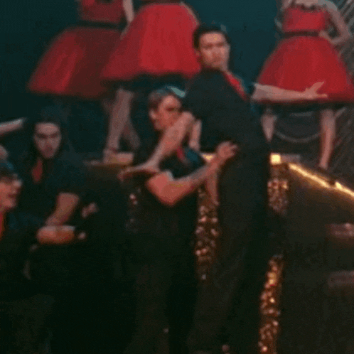 a man in a black shirt is being lifted by another man in a red dress