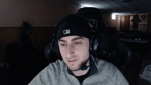 a man wearing a beanie and headphones with a mlb logo on it