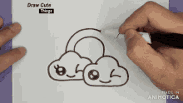 a person is drawing a cloud with a rainbow in it