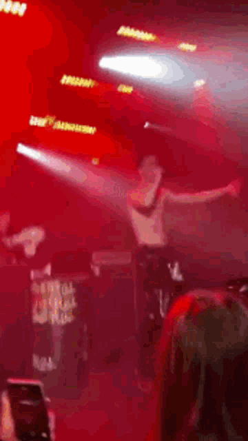 a man without a shirt is dancing on a stage with his arms outstretched