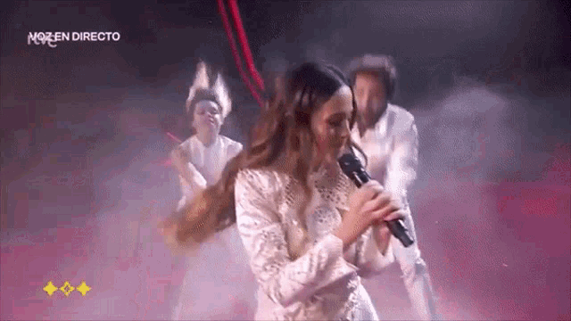 a woman singing into a microphone with the word nozen directo on the bottom right