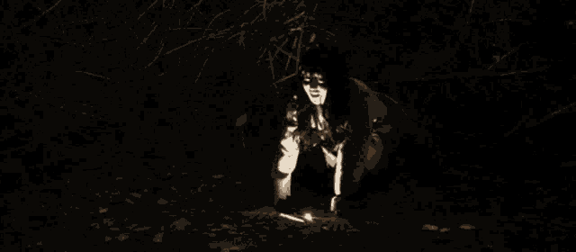 a woman crawling in the dark with a light shining on her