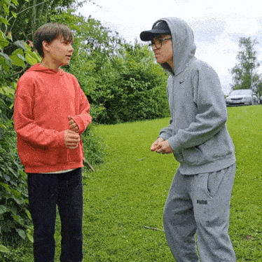 a man wearing a puma sweatpants stands next to another man