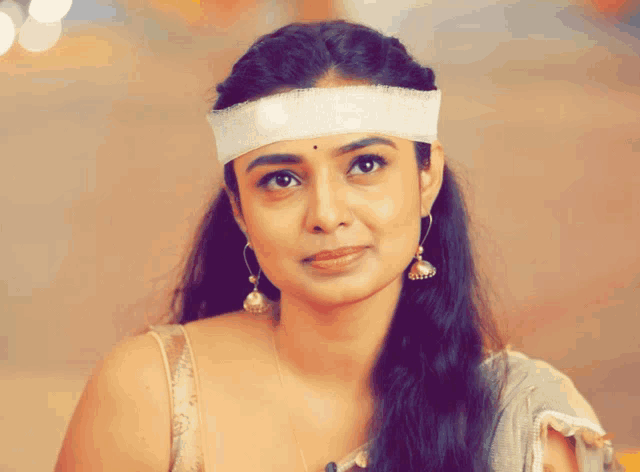 a woman with a bandage on her forehead looks at the camera