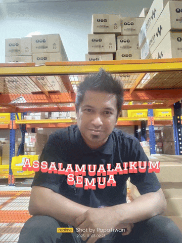 a man sitting in front of a stack of boxes with the words assalamualaikum semua written in red