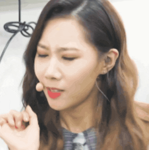 a close up of a woman wearing a microphone in her mouth