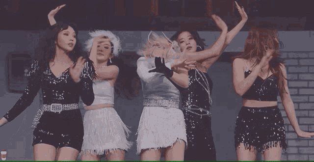 a group of young women are dancing together in a room