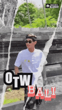 a man wearing sunglasses and a headband stands in front of a sign that says " otw bali "