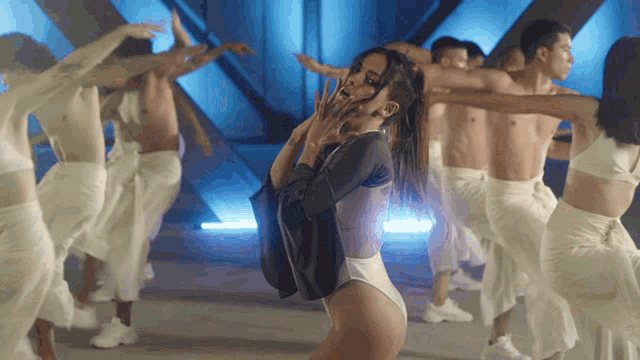 a woman in a leotard is dancing with a group of men