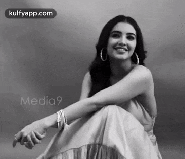 a black and white photo of a smiling woman in a dress