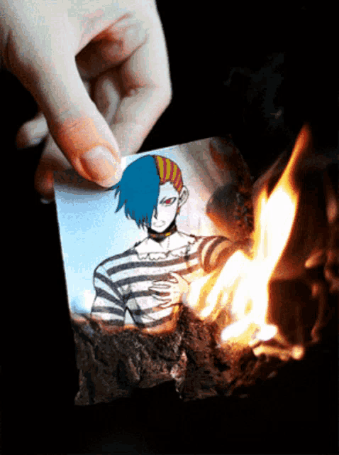 a person is holding a piece of paper with a picture of a man with blue hair on it