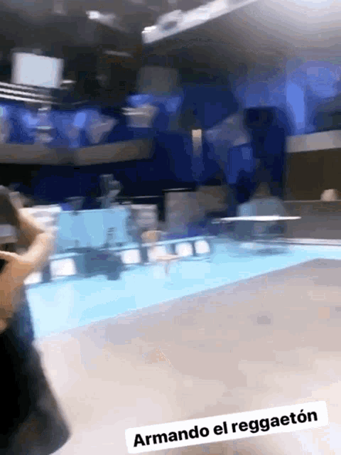 a person standing in front of a pool with the words armando el reggaeton below them