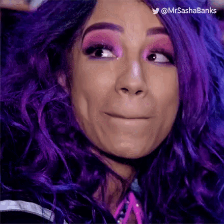 a woman with purple hair and pink makeup is making a funny face .