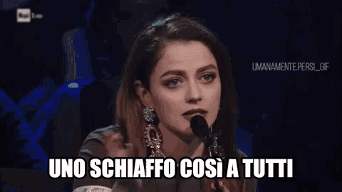 a woman is speaking into a microphone and the words uno schiaffo così a tutti are written below her