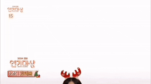 a woman wearing a reindeer headband is smiling in front of a sign that says mc