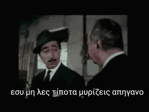a man in a hat and tie is talking to another man in a suit and tie .