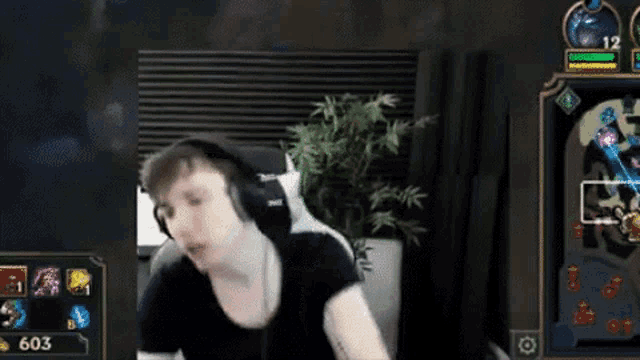 a man wearing headphones is playing a video game in a room .