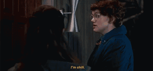 a woman in glasses is talking to another woman in a dark room .