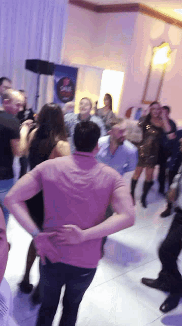 a group of people are dancing in a room with a sign that says salsa on it