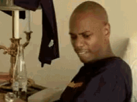 a man is sitting in a chair in front of a table with a bottle of water .