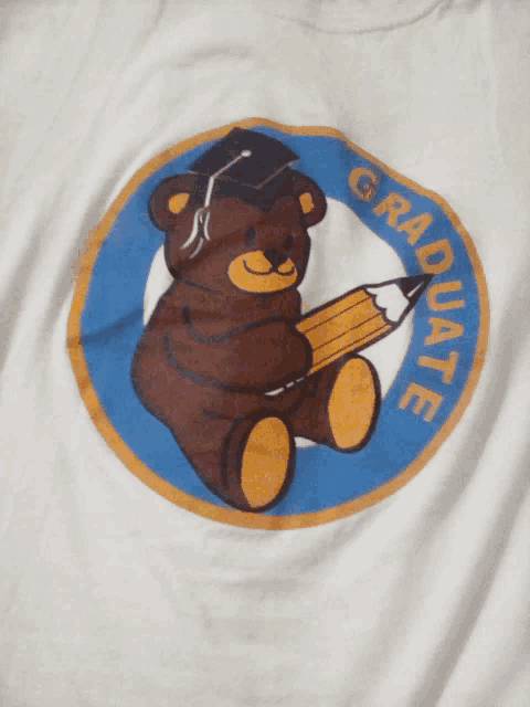 a teddy bear wearing a graduation cap and holding a pencil with the words graduate written around it