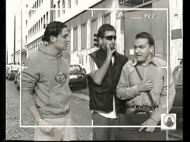 three men are standing in front of a camera that says rcc