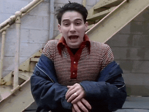 a man wearing a plaid shirt and a blue jacket with his mouth open