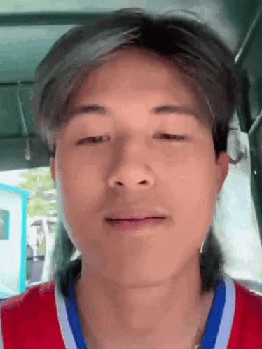 a close up of a man 's face wearing a red and blue shirt