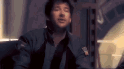 a man in a space suit is sitting in a chair in a room .