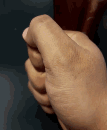a close up of a person 's fist on a black surface