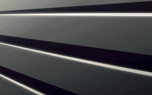 a close up of a black and white striped wall with a light coming out of it