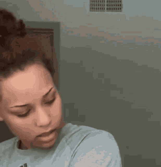 a woman in a blue shirt is standing in front of a door .