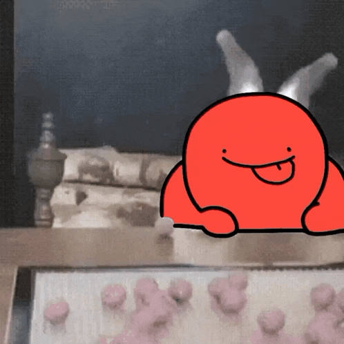 a red cartoon character with horns is sitting on a table