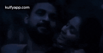 a man and a woman are hugging in a dark room with the website kulfyapp.com visible in the corner