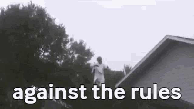 a man is jumping off the roof of a house with the words `` against the rules '' written below him .