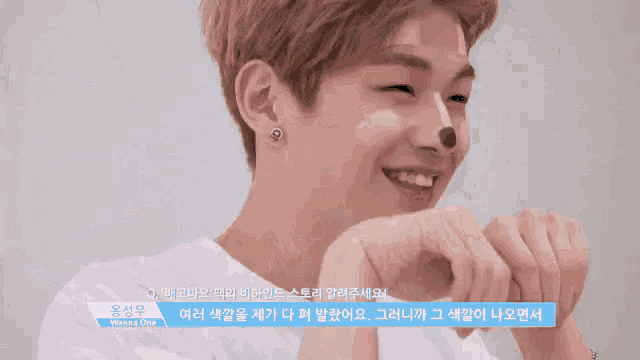a young man with a sticker on his nose that reads wanna one