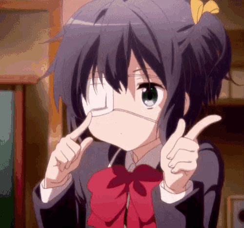 a girl with a bandage on her eye is making a funny face .