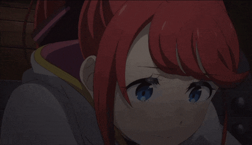 a girl with red hair and blue eyes is looking at something