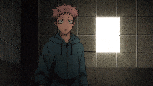 a man in a blue hoodie stands in front of a white square