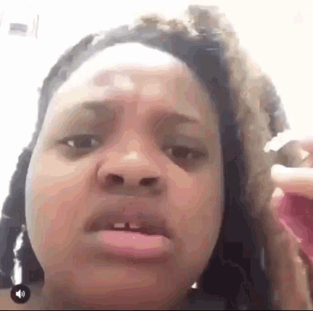 a woman is making a funny face while holding a brush in her hand .