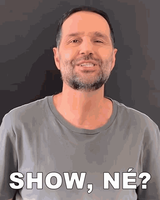 a man with a beard is smiling and says " show ne "