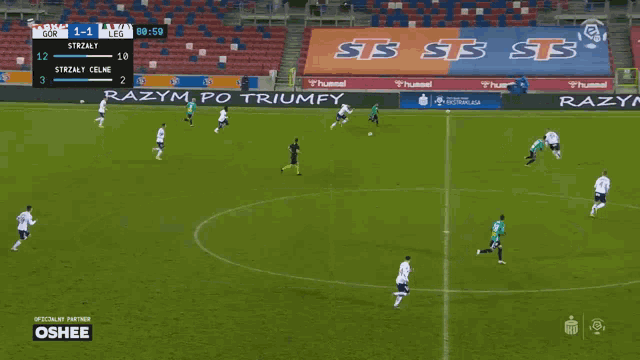 a soccer game is being played on a field with ads for hummel and oshee on the sidelines