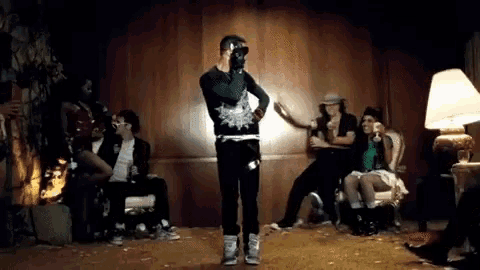 a group of people are gathered in a living room including a man wearing sunglasses