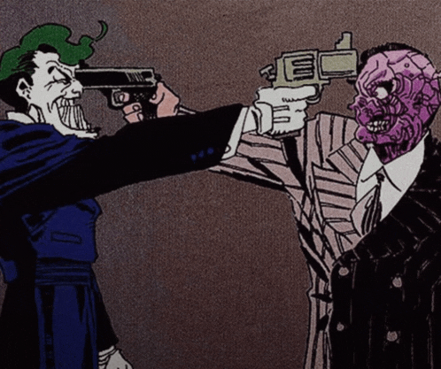 the joker is pointing a gun at two face who is holding a gun