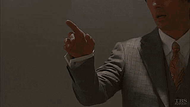 a man in a suit and tie is standing in front of the ocean and says `` not perfect '' .
