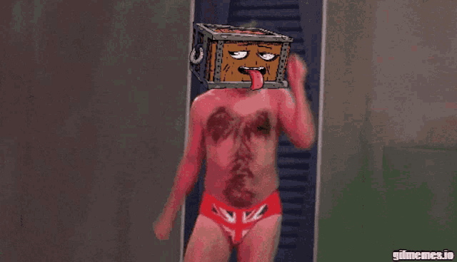 a man in red underwear is holding a box on his head with a face on it
