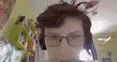 a man wearing glasses and headphones looks at the camera .