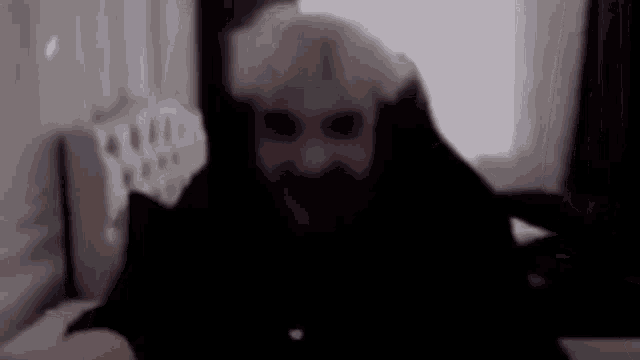 a man with a beard and blonde hair is sitting on a bed .