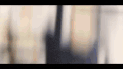 a blurry picture of a man in a suit and tie standing next to a woman .