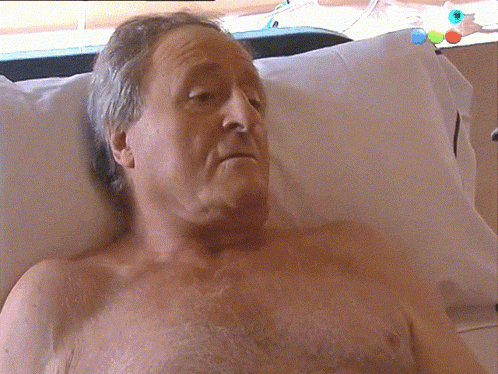 a man without a shirt is laying in a bed
